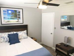 a bedroom with a bed with a blue pillow and a window at Modern Apartment - 1 of 4 in Punta Gorda