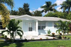a white house with palm trees in front of it at Modern Apartment - 1 of 4 in Punta Gorda