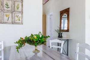 a dining room table with a vase of flowers on it at Althea in Panormos Skopelos