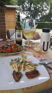 uma mesa com um prato de comida e um copo de vinho em Casa Gaia em Poggio Murella