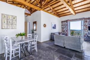 Una sala de estar con una mesa y sillas y un sofá. en ALTHEA, en Panormos Skopelos
