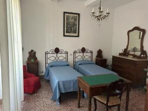 een slaapkamer met 2 bedden, een tafel en een spiegel bij Villa con ampio giardino a due passi dal mare in SantʼAnna