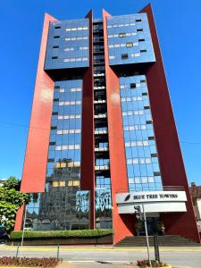 duży czerwony budynek z niebieskimi oknami na ulicy w obiekcie Blue Tree Towers Joinville w mieście Joinville