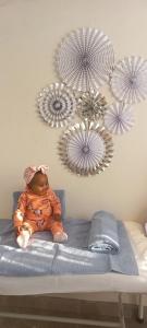 ein Baby auf einem Bett in einem Zimmer in der Unterkunft Karee Gardens B&B in Springs