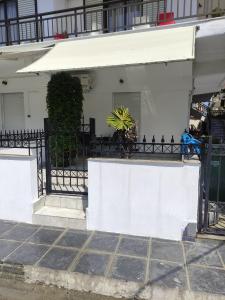 a white house with a fence and a plant at White coral 2 in Paralia Katerinis
