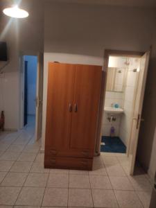 a bathroom with a wooden cabinet in the middle of a room at White coral 2 in Paralia Katerinis