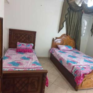 a bedroom with two twin beds and a window at Tanta طنطا Families Only in Tanta