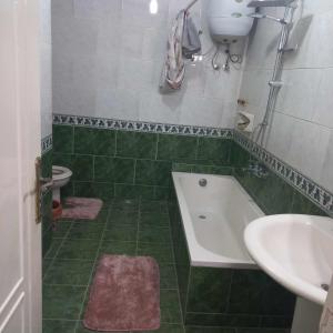 a green and white bathroom with a tub and a sink at Tanta طنطا Families Only in Tanta