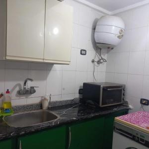 a kitchen counter with a sink and a microwave at Tanta طنطا Families Only in Tanta