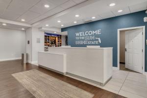 a lobby with a welcome sign on a blue wall at Holiday Inn Express & Suites Destin - Miramar Beach by IHG in Destin