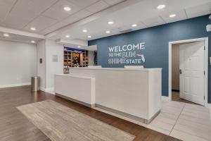 a lobby with a welcome sign on a blue wall at Evoke Destin Hotel in Destin