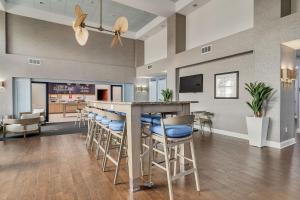 uma cozinha e sala de jantar com um bar e bancos em Evoke Destin Hotel em Destin