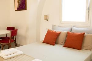 Habitación con cama con almohadas de color naranja y blanco en Casale alle Vigne, en Nardò