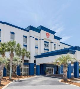 a hotel with palm trees in front of it at Evoke Destin Hotel in Destin