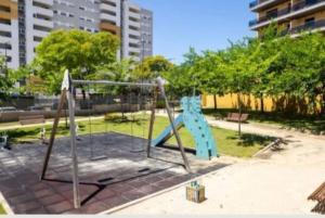 um parque infantil num parque com um baloiço em Vacaciones perfectas. em Paterna