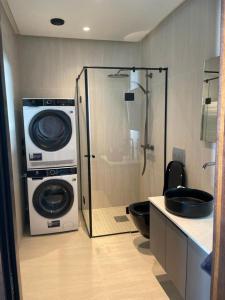 a bathroom with a shower and a washing machine at Madla in Stavanger
