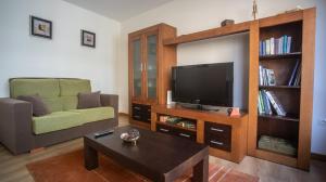 sala de estar con TV, sofá y mesa de centro en Apartamento nuevo al lado de la playa en A Guarda, en A Guarda