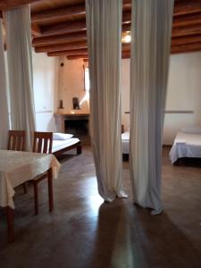 a room with two beds and a table with curtains at Filippos villa in Gialiskari