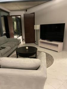 uma sala de estar com um sofá, uma mesa e uma televisão em Madla em Stavanger
