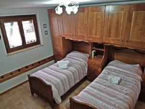 2 camas en una habitación con armarios de madera en Villetta La Pigna, en Castel di Sangro