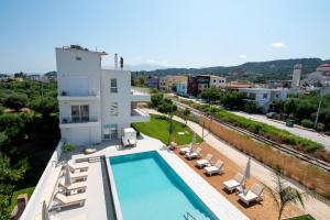 a building with a swimming pool next to a resort at Ennea Suites-Null suite in Flámbouras