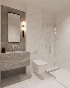 een badkamer met een wastafel, een toilet en een spiegel bij Downtown Suites by Athens Tower Hotel in Athene
