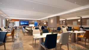 a restaurant with tables and chairs and a flat screen tv at Holiday Inn Express Shanghai Pujiang Lianhang Road, an IHG Hotel in Shanghai