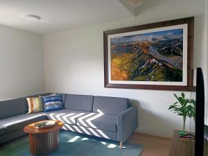 a living room with a couch and a painting on the wall at Puffin Nest, Superior Apartment in Reykjavík