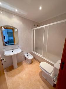 ein Bad mit einem WC, einem Waschbecken und einer Dusche in der Unterkunft Apartamentos Canada in Raxo