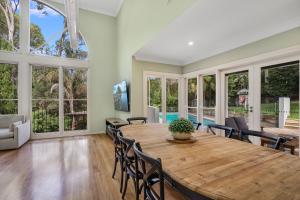 Un comedor con mesa y sillas de madera. en Karinya Parkland Estate, en Lambton