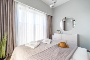 a bedroom with a bed with a hat on it at Apartament Słoneczny Bulwar Ustka in Ustka