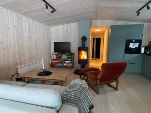 - un salon avec un canapé, une table et une cheminée dans l'établissement Vegglihytta - cabin with a tranquil location, à Veggli