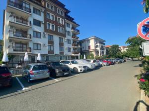 a row of cars parked in a parking lot next to a building at FREGATA 2 Studio Sveti Vlas in Sveti Vlas