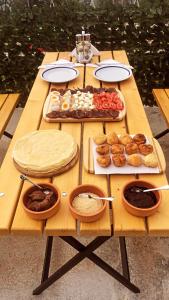 a wooden picnic table with food on it at Seosko domacinstvo Becirovic - Kukulik lodgings in Bijelo Polje