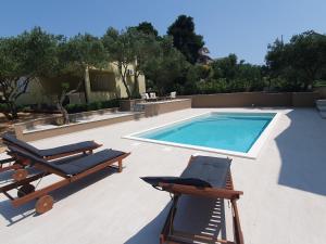 a swimming pool with two loungers and a swimming pool at Holiday house in Drage with sea view, balcony, air conditioning,W-LAN 571-1 in Drage