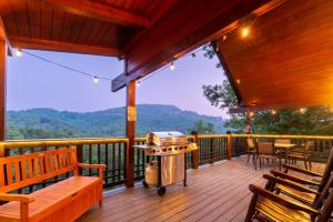 een grill op een houten terras met een tafel en stoelen bij Summer Special! stunning views, near attractions in Sevierville