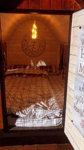 Cette chambre dispose d'un lit avec une horloge murale. dans l'établissement Seosko domacinstvo Becirovic - Kukulik lodgings, à Bijelo Polje