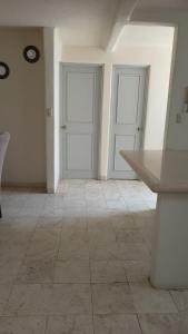 une chambre vide avec deux portes blanches et du carrelage dans l'établissement Casa Mar_bella 14, à Acapulco