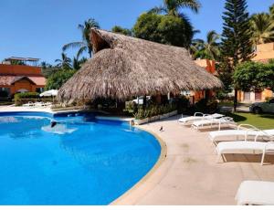 - une piscine avec des chaises et un parasol dans l'établissement Casa Mar_bella 14, à Acapulco