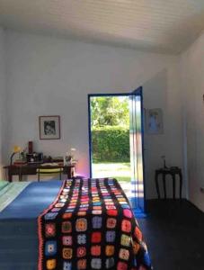a bedroom with a bed with a colorful blanket on it at Casa da árvore in Ubatuba