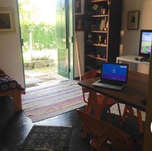 a laptop computer sitting on a table in front of a door at Casa da árvore in Ubatuba