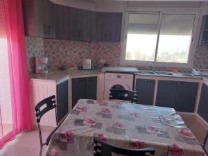 a kitchen with a table and a table and a table and chairs at Résidence kelibia waves in Kelibia