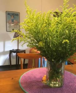 a vase with yellow flowers sitting on a table at Casa da árvore in Ubatuba