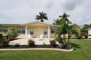a house with two white chairs in a yard at Modern Apartment - 3 of 4 in Punta Gorda
