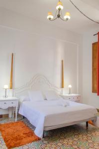 a white bedroom with a white bed and two white tables at Hotel rural casona Santo Domingo in Güimar