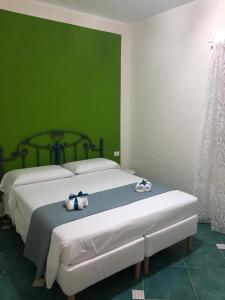 a bedroom with a large white bed with a green wall at La Strettoia in Caprioli