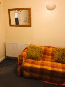 a bedroom with a bed with a blanket and a mirror at Tatia House in Gainsborough