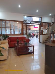 Sala de estar con sofá rojo y mesa de centro en Hotel Palermo Quintero en Quintero