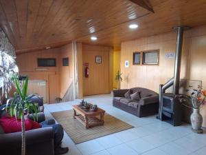 sala de estar con sofá y TV en Hotel Palermo Quintero en Quintero