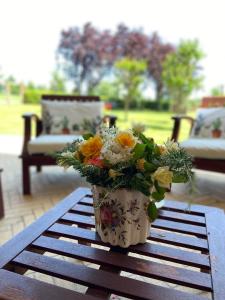un vaso pieno di fiori seduto su un tavolo di Lemon tree suite al golf a Miglianico